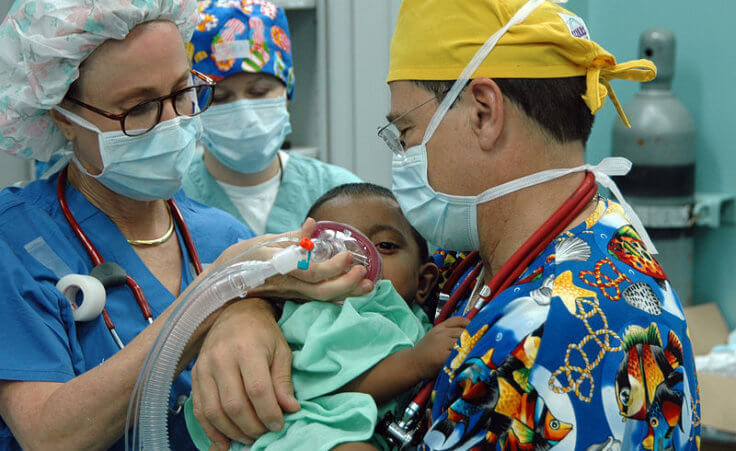 Chittagong, Bangladesh (July 2, 2006) – Operation Smile volunteers Janet Casabon Benowitz and Dr. Bill Pond anesthetize a young child before undergoing corrective plastic surgery on his cleft lip aboard U.S. Naval hospital ship USNS Mercy (T-AH 19), during the ship’s visit to provide humanitarian and civic assistance to the people of Bangladesh (Credit: US Navy/photo by Mass Communication Specialist Seaman Joseph Caballero)