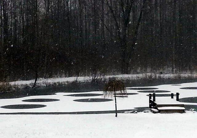 A pond during an early spring snowstorm near the home of Eden, New York resident Peggy Gervase, with an unusual pattern of circles in the snow covering the water's surface (Credit: Peggy Gervase via Facebook)