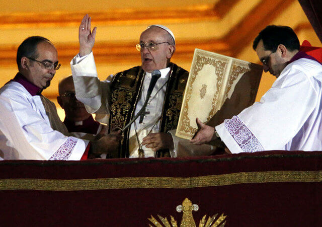 Newly elected Pope Francis (C), the 266th pontiff of the Roman Catholic Church, former Cardinal Jorge Mario Bergoglio of Argentina, appears on the central balcony of St. Peter's Basilica at the Vatican to bless the crowd after being elected by the conclave of cardinals, at the Vatican, March 13, 2013 (Credit: Reuters / Tony Gentile)