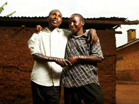 Gespard (R), puts his arm around, and holds hands with, a man named Innocent (L), who killed Gespard's brother, along with four other people during the Rwandan Genocide in 1994 (Credit: www.jeremycowart.com)
