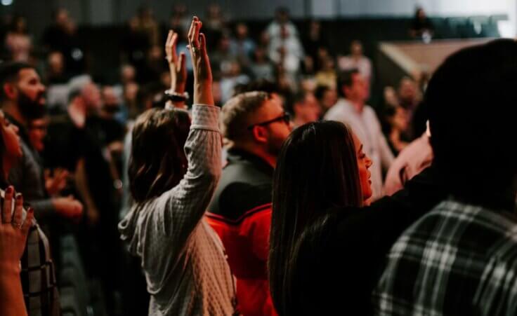 Hands in the air of people who praise God at church service. By tutye/stock.adobe.com