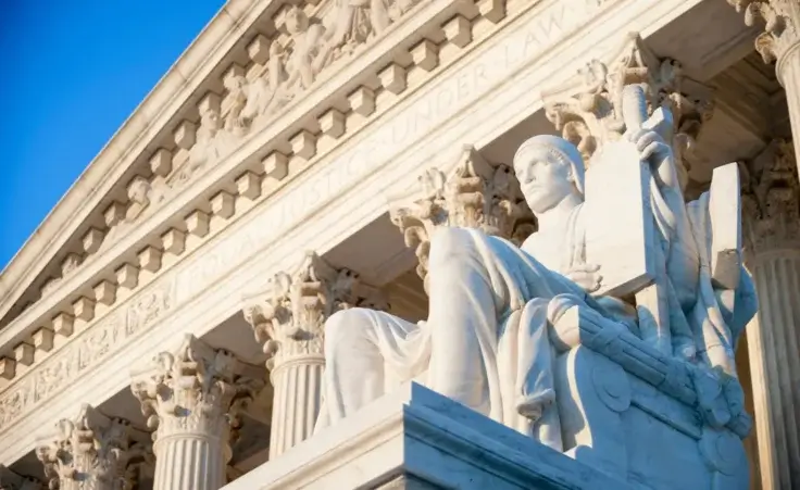 Neoclassical columned entrance portico to the U.S. Supreme Court building in Washington, D.C. By lazyllama/stock.adobe.com. President Biden