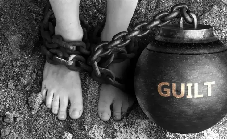 Guilt as a negative aspect of life - symbolized by the word guilt and chains to show the burden and bad influence of guilt. By GoodIdeas/stock.adobe.com