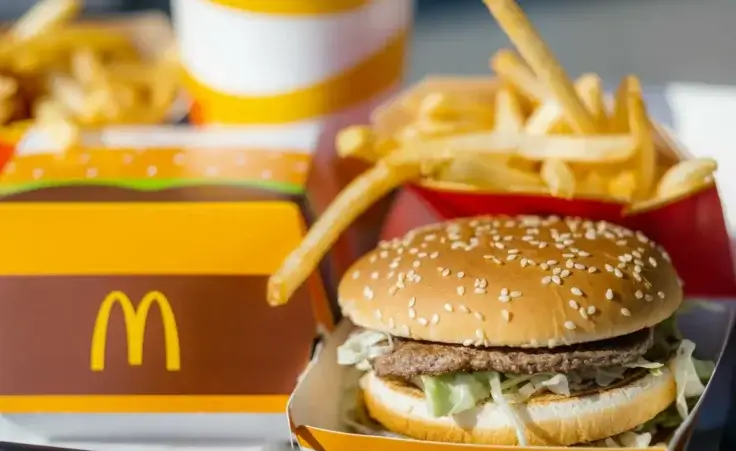 Tray full of fast food in McDonalds Restaurant. Cheeseburger, French fries, and soda to illustrate the recent E. coli outbreak. By FOTO_STOCKER/stock.adobe.com