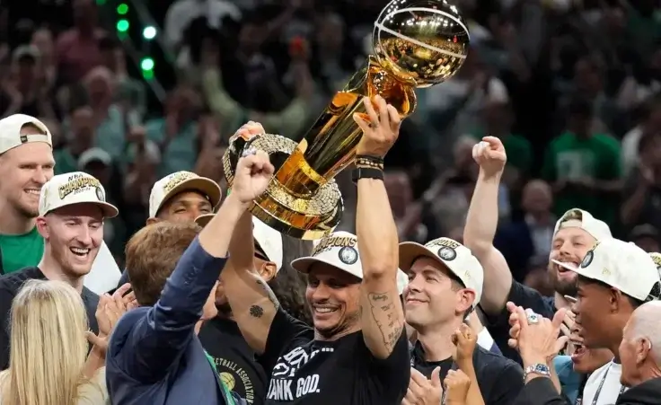 Boston Celtics head coach Joe Mazzulla, center, celebrates with the team as he holds up the Larry O'Brien Championship Trophy after they won the NBA basketball championship with a Game 5 victory over the Dallas Mavericks, Monday, June 17, 2024, in Boston. (AP Photo/Charles Krupa)