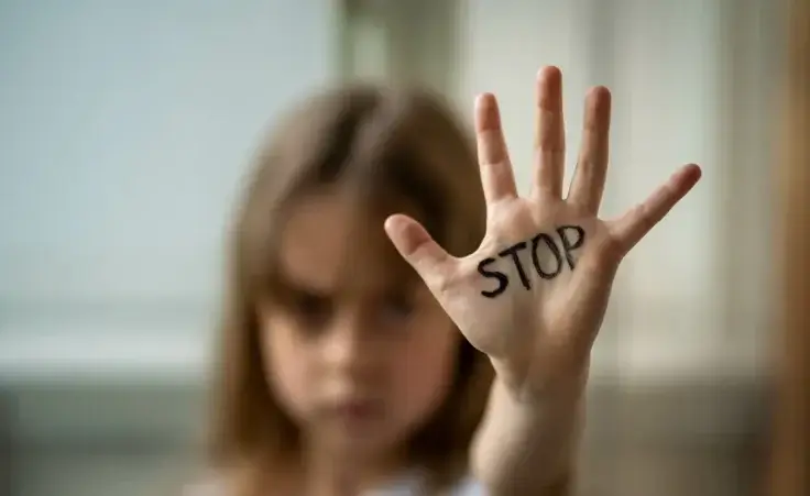 A child makes a stop gesture with his hand to illustrate stopping abuse. By mihakonceptcorn/stock.adobe.com