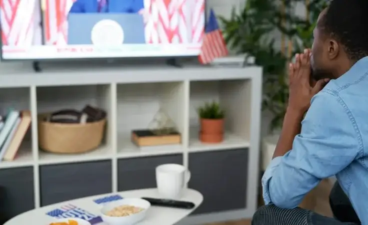 Man stressed while watching USA election results to illustrate the need for biblical contentment during such times. By gpointstudio/stock.adobe.com