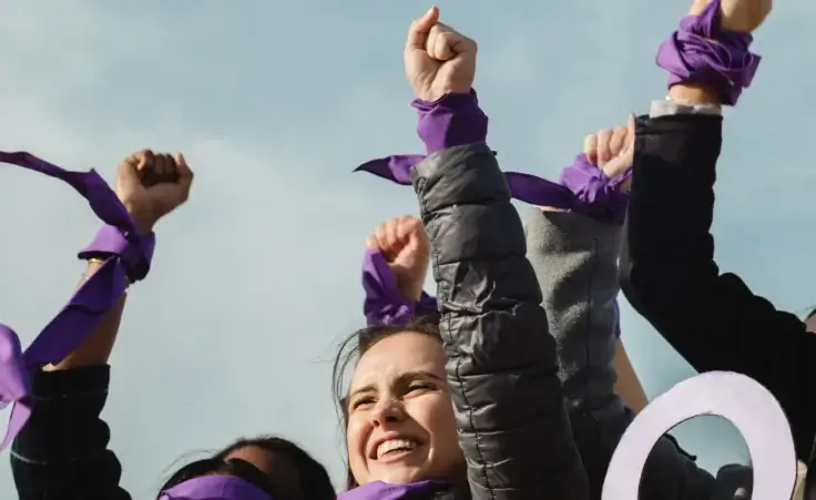 Women at a women's rights rally with purple cloths tied on their wrists to represent feminism. By Clara/stock.adobe.com. 4B movement