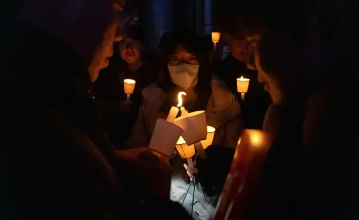 Attendees light each other's candles during a candlelight vigil against South Korean President Yoon Suk Yeol in Seoul, South Korea, Wednesday, Dec. 4, 2024. (AP Photo/Ng Han Guan)