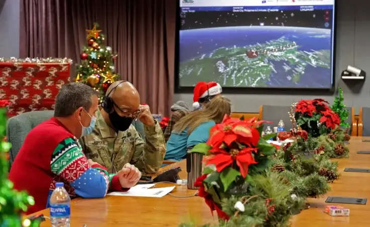 This image provided by the Department of Defense shows volunteers answering phones and emails from children around the globe during the annual NORAD Tracks Santa event on Peterson Air Force Base in Colorado Springs, Colo., Dec. 24, 2021. (Chuck Marsh/Department of Defense via AP)