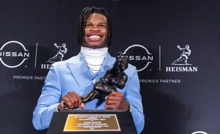 Heisman Trophy winner Travis Hunter, of Colorado, poses with the trophy at a press conference after the awards ceremony, Saturday, Dec. 14, 2024, in New York, (AP Photo/Corey Sipkin)