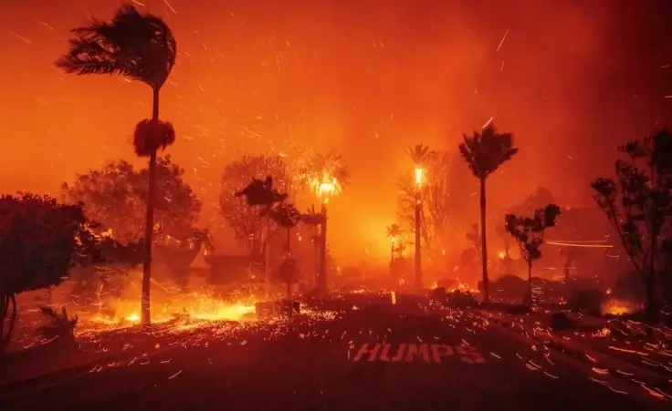 The Palisades Fire ravages a neighborhood amid high winds in the Pacific Palisades neighborhood of Los Angeles, Tuesday, Jan. 7, 2025. (AP Photo/Ethan Swope)