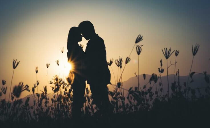 Silhouette of a couple in love during sunset in a beautiful setting. By Johnstocker/stock.adobe.com