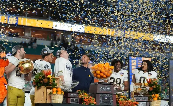 Notre Dame head coach Marcus Freeman, center, and members of the team celebrate after winning the Orange Bowl College Football Playoff semifinal game against Penn State, Thursday, Jan. 9, 2025, in Miami Gardens, Fla. (AP Photo/Rebecca Blackwell)