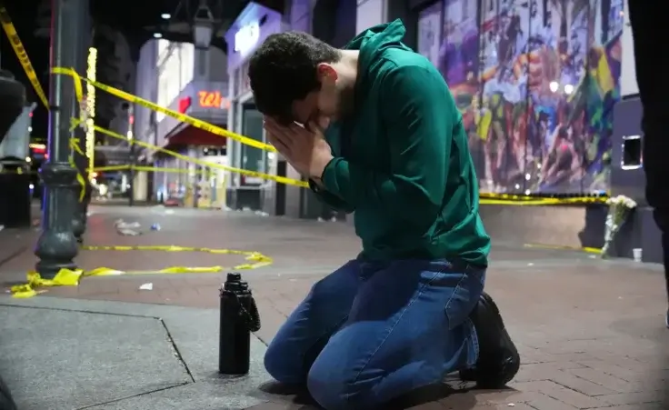 Matthias Hauswirth of New Orleans prays on the street near the scene where a vehicle drove into a crowd on New Orleans' Canal and Bourbon streets, Wednesday, Jan. 1, 2025. (AP Photo/George Walker IV)