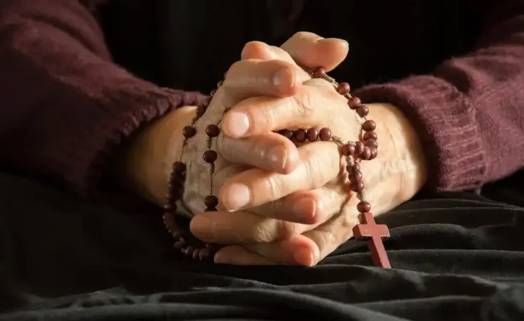 World's oldest living person clasping a rosary. By dorotaemiliac/stock.adobe.com.