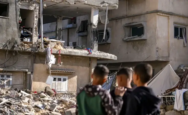 Palestinians look at a damaged residential building following an overnight Israeli strike in Deir al-Balah, Gaza Strip, Wednesday, Jan. 8, 2025. (AP Photo/Abdel Kareem Hana, File) deal to end war in gaza ceasefire