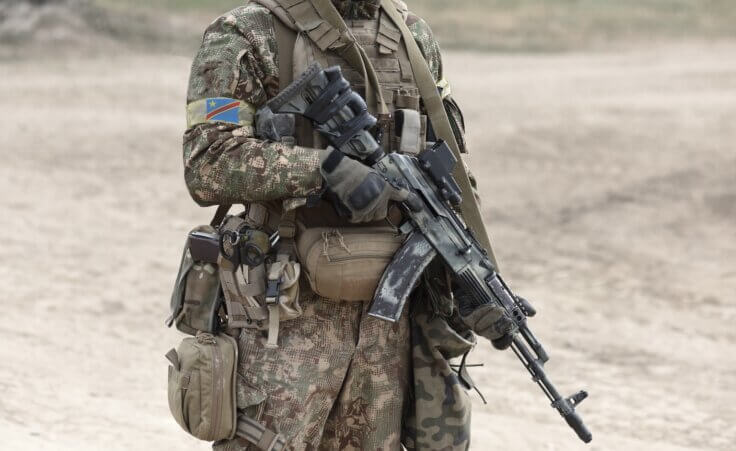 Soldier with machine gun and flag of Democratic Republic of the Congo on military uniform. By Bumble Dee/stock.adobe.com