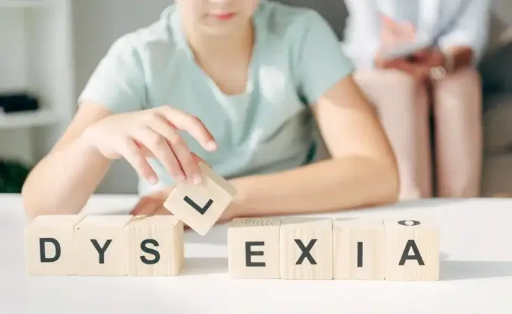 cropped view of kid with dyslexia sitting at table and playing with wooden cubes by LIGHTFIELD STUDIOS/stock.adobe.com