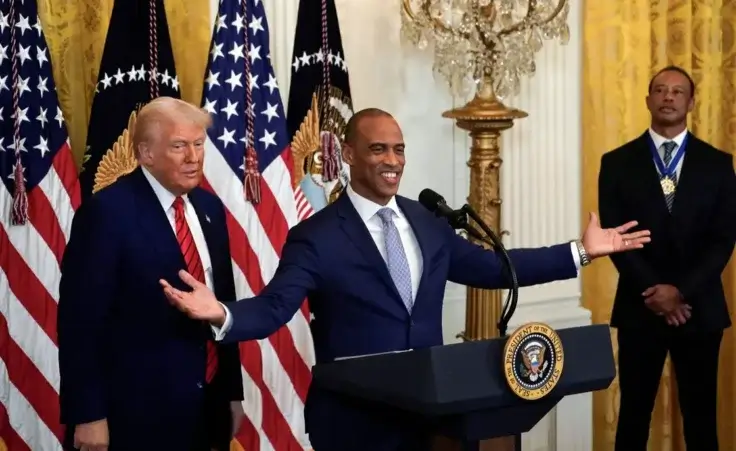 Housing and Urban Development Secretary Scott Turner speaks as President Donald Trump and Tiger Woods listen during a reception for Black History Month in the East Room of the White House Thursday, Feb. 20, 2025. (Pool via AP)