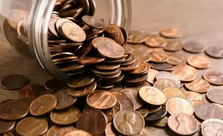 Glass jar with coins on table, closeup. Money saving concept By New Africa/stock.adobe.com