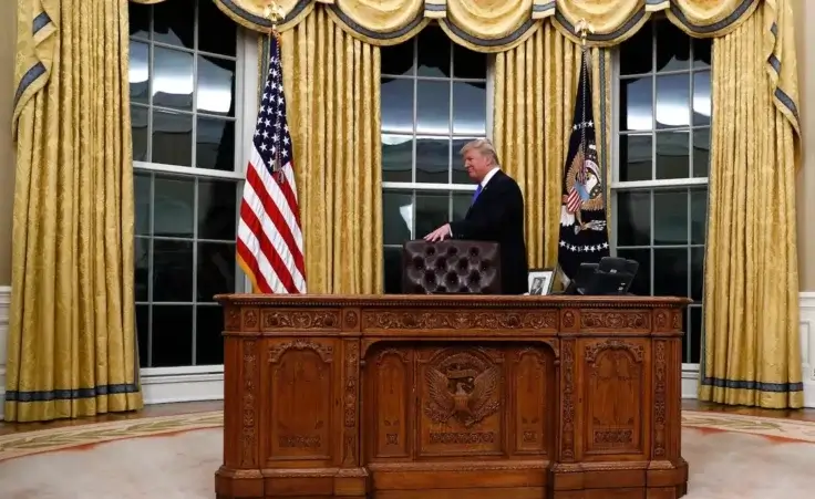 President Donald Trump walks around the Resolute desk during a ceremony in Oval Office of the White House in Washington, Wednesday, Feb. 1, 2017, for the swearing in ceremony of Rex Tillerson as Secretary of State. (AP Photo/Carolyn Kaster)